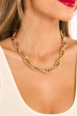 Model shown wearing necklace that features a gold chain link pattern, and lobster clasp.