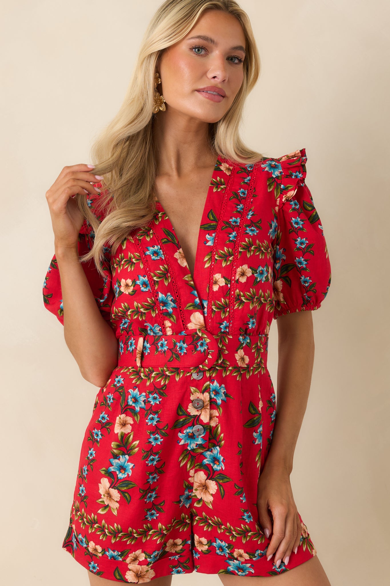Red multi floral romper highlighting the decorative button-front design and printed fabric.