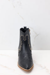 Front view of these ankle boots that feature a pointed toe, a side zipper closure, a stretchy side panel, embroidered detailing, and a stacked heel.