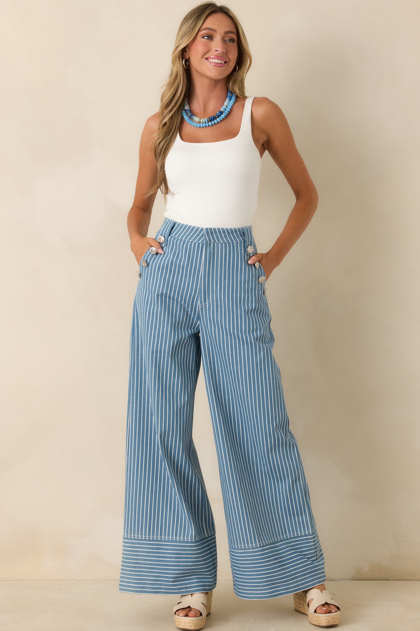 Blue striped pants with a flowing wide leg shape and contrasting striped hem panel for added definition.