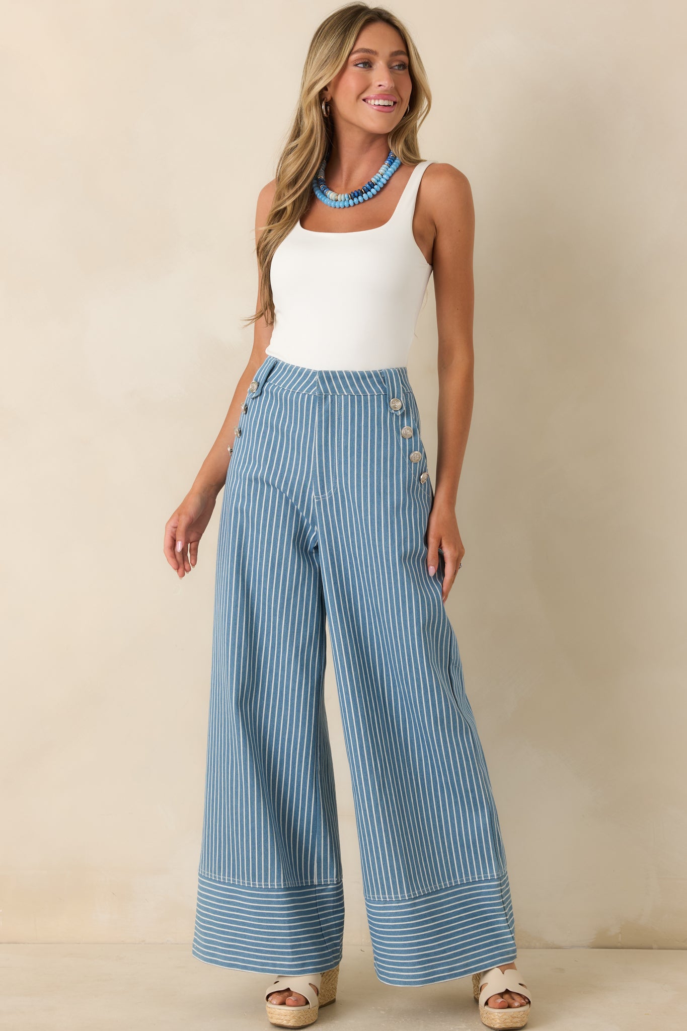 High-waisted blue trousers showcasing wide leg silhouette, functional front pockets, and crisp striped patterning.