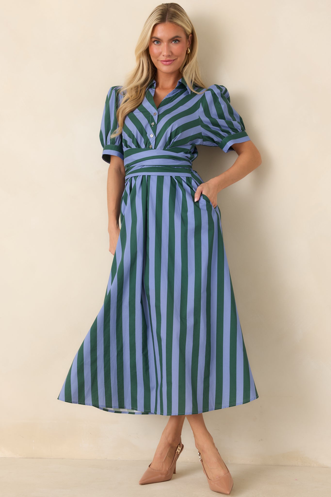 Blue and green striped cotton midi dress with a collared neckline, functional button front, puff sleeves, and a wide wrap-style sash that cinches the waist above a flowing skirt.