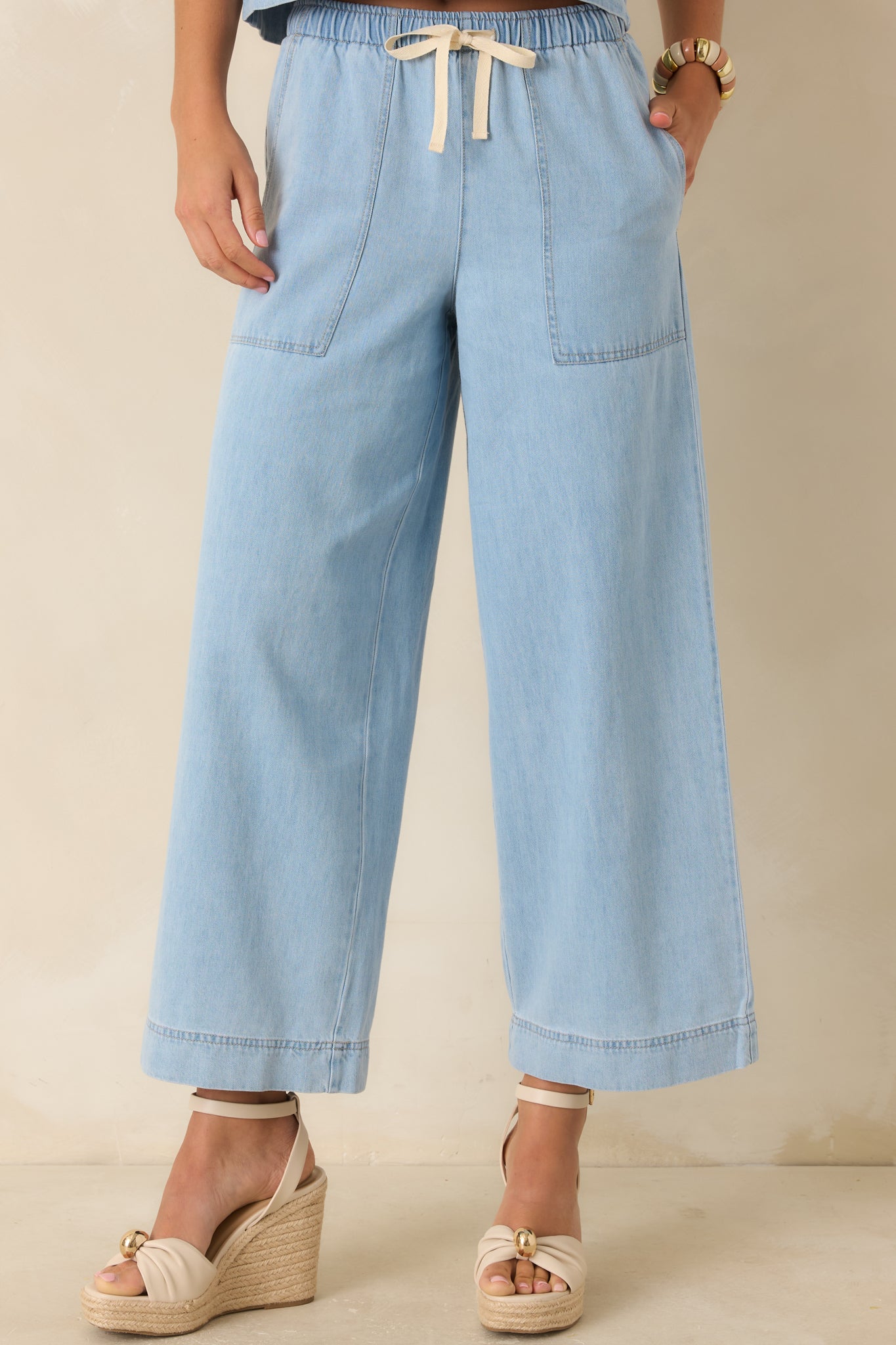 Elastic waistband detail with adjustable drawstring tie on denim pants.