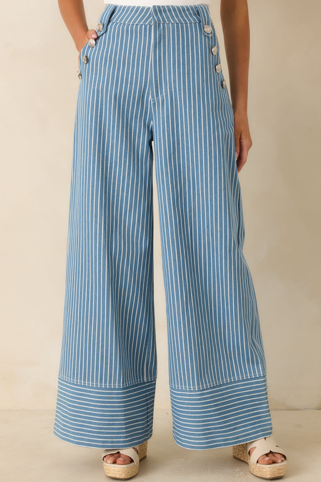 Cropped view of blue striped pants highlighting the high-rise waistband and structured cotton blend fabric finish.