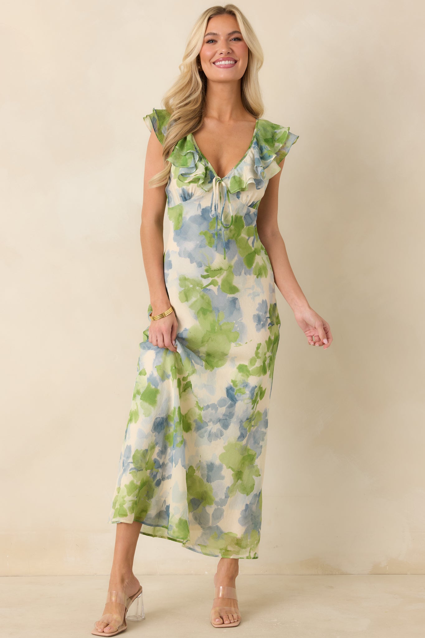Floral print midi dress with ruffled cap sleeves, tie neckline detail, and graceful flowing silhouette.