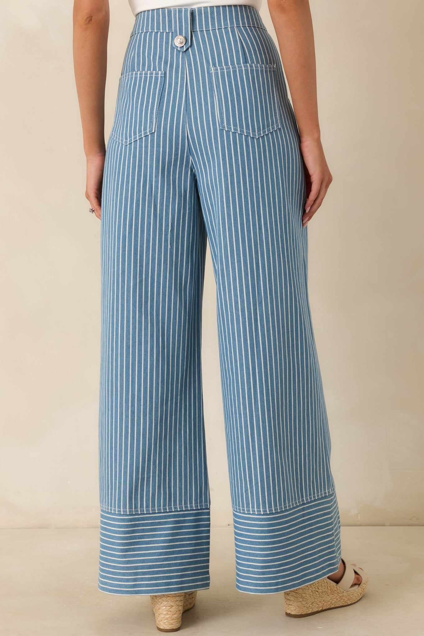 Rear view of blue striped wide leg pants featuring back pockets, high-rise waistband, and wide leg silhouette.