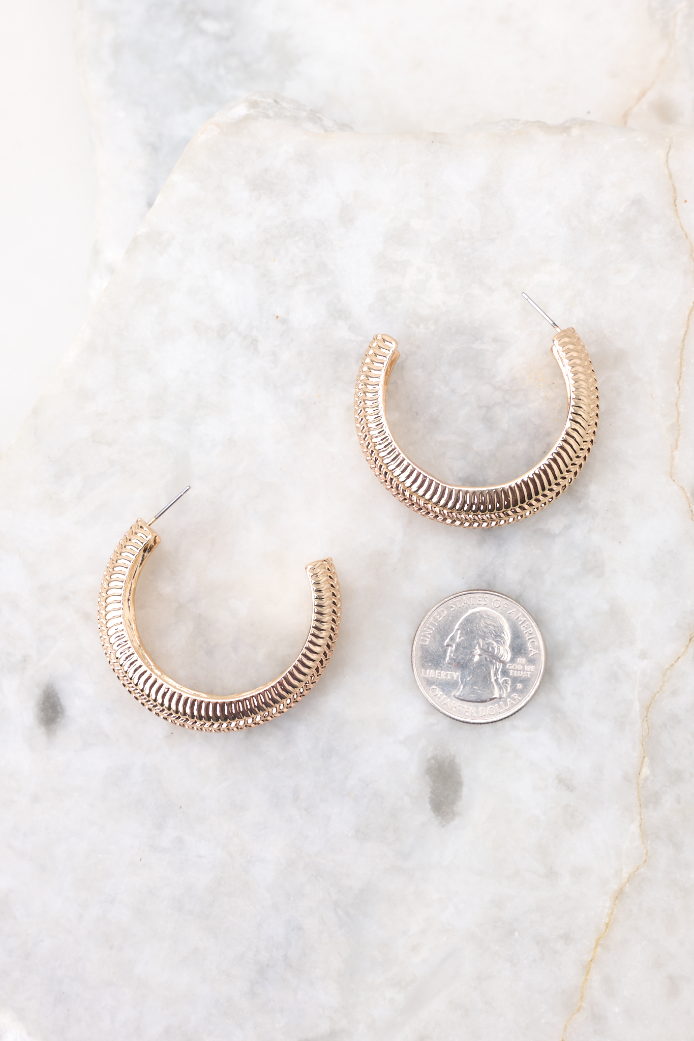 Gold hoop earrings compared to quarter for actual size. 
