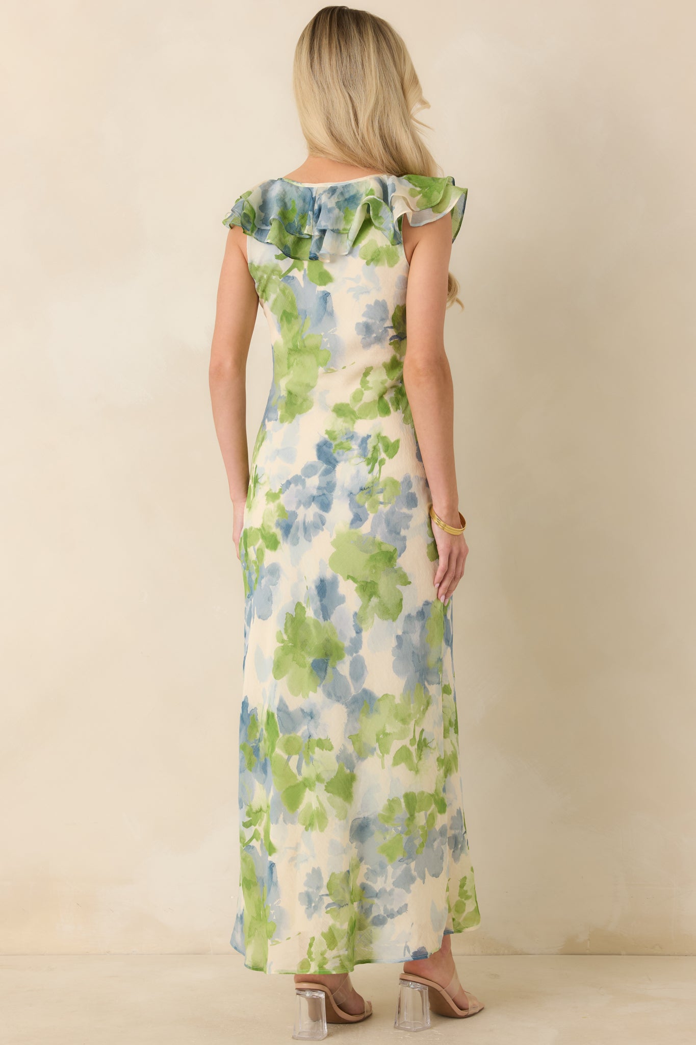 Rear view of blue and green floral midi dress with flowing skirt and softly fitted bodice.