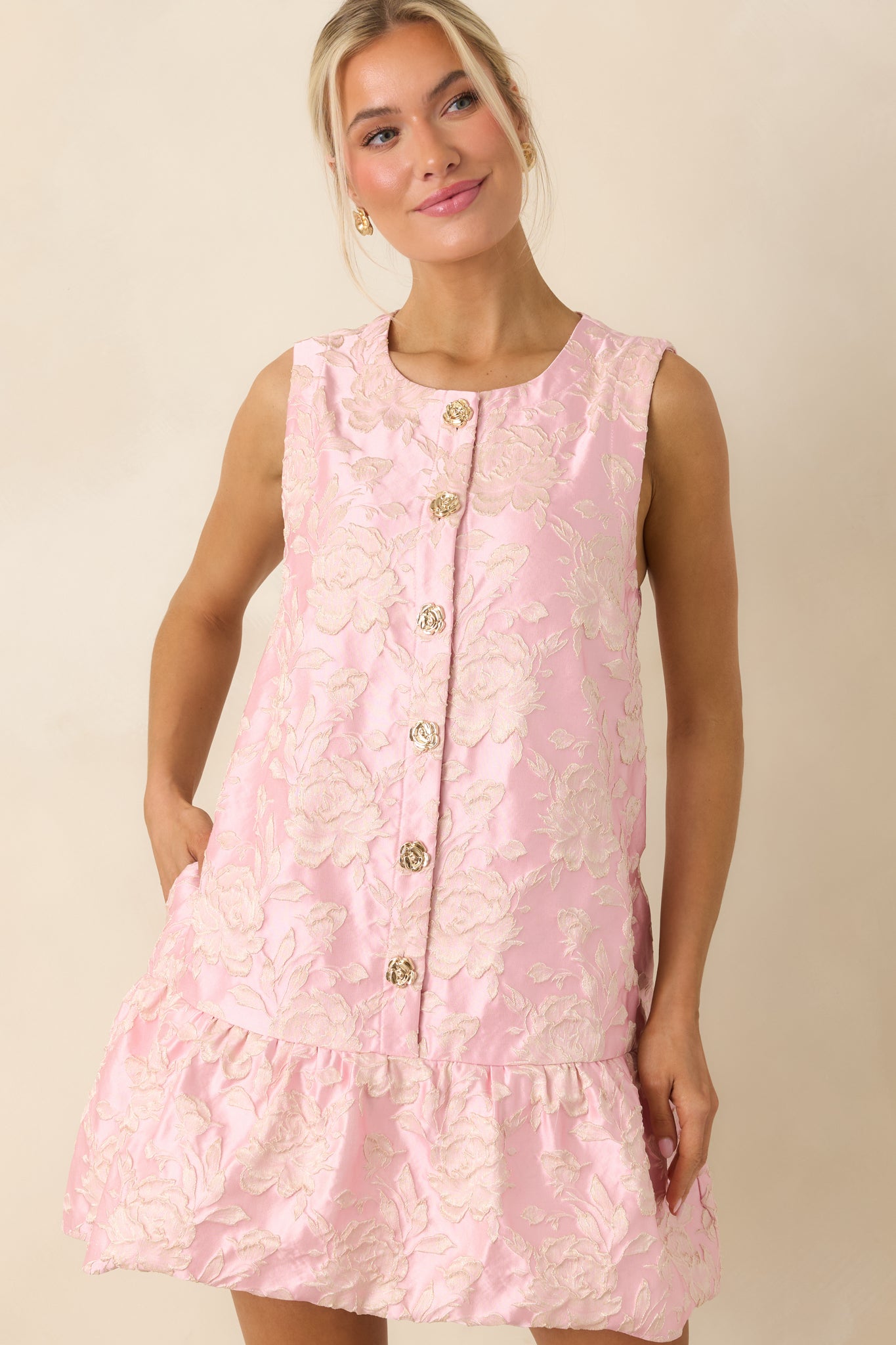 Close view of gold flower buttons and textured floral jacquard fabric detail.