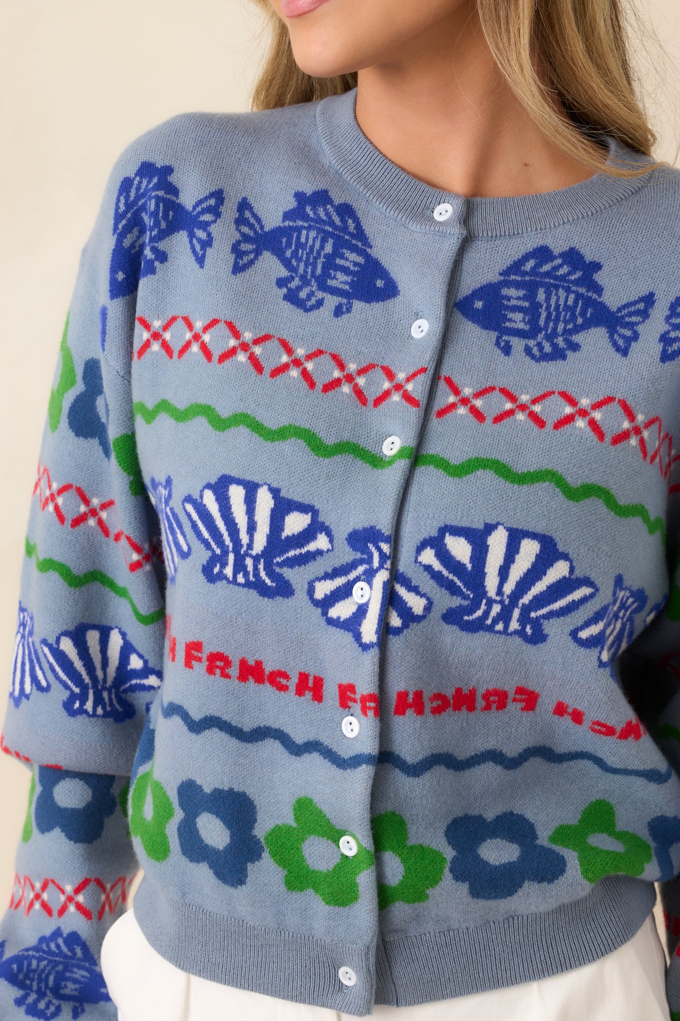 Close-up of jacquard knit texture with fish, shell, and geometric motifs.