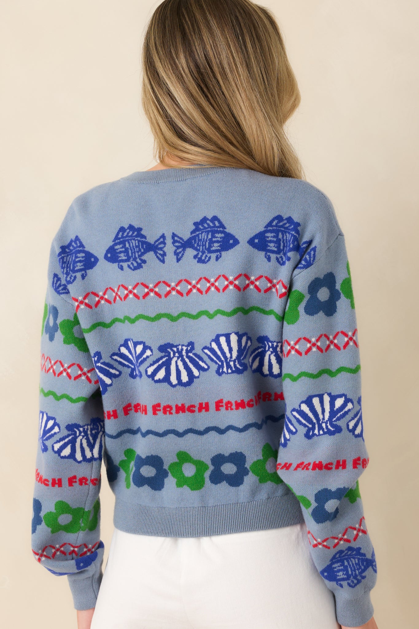 Rear view of dusty blue knit cardigan with ribbed hem and structured fit.