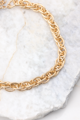 Detailed view of necklace that features a gold chain link pattern with a lobster clasp and measures 8