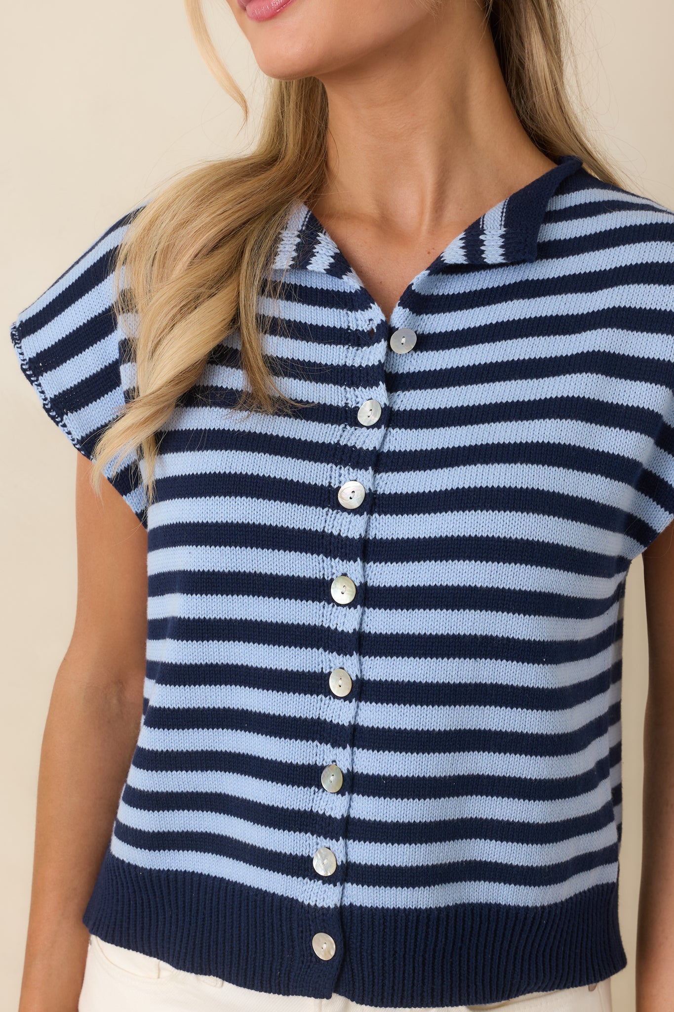 Detailed view of soft knit texture with pearlescent-style button and stripe pattern.