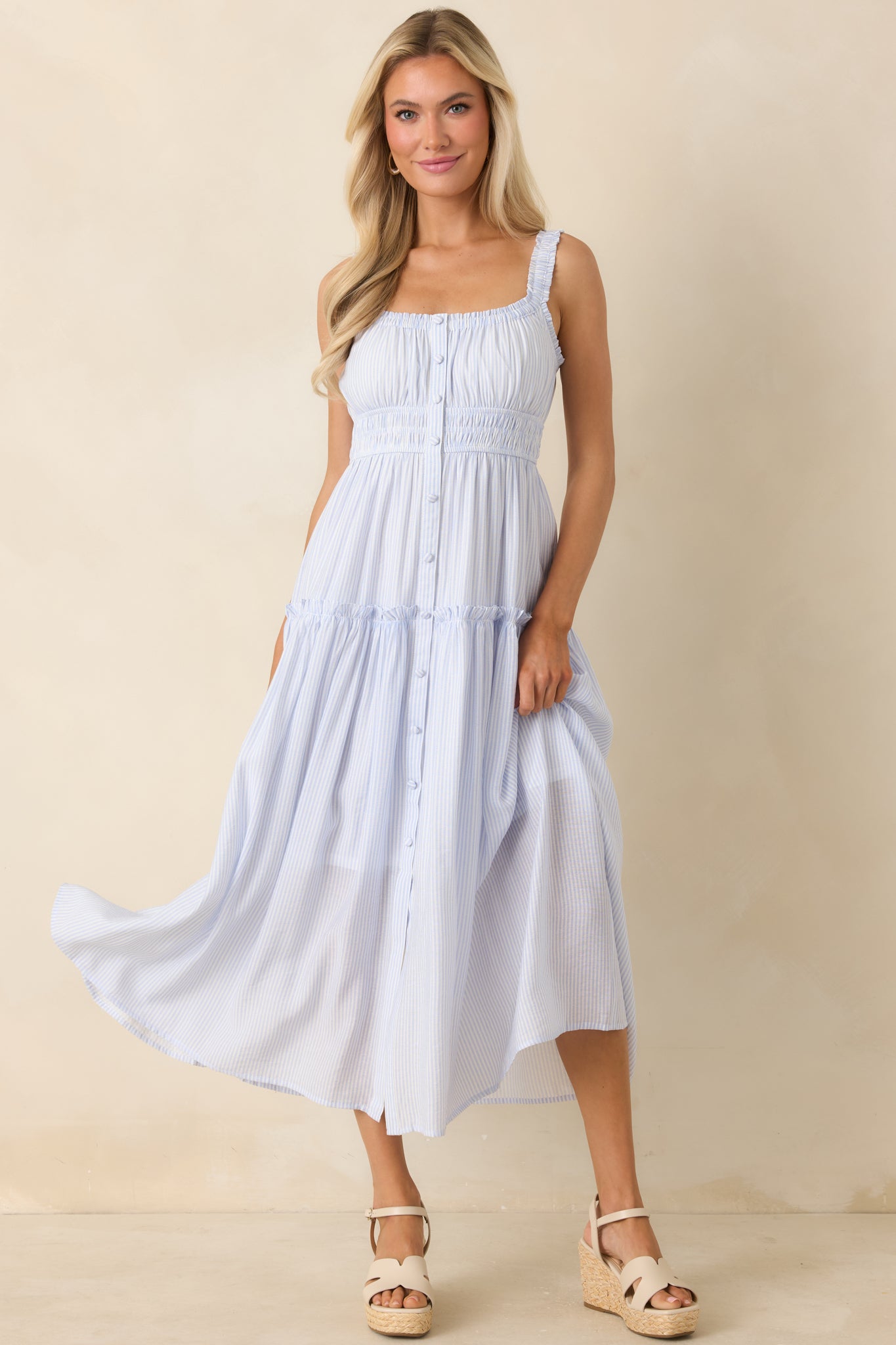 Flowy pinstripe dress featuring a tiered silhouette, gathered neckline, and delicate ruffle straps.