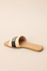 Inner-side view of these sandals that feature a strap across the top of the foot with the name of a tropical location.