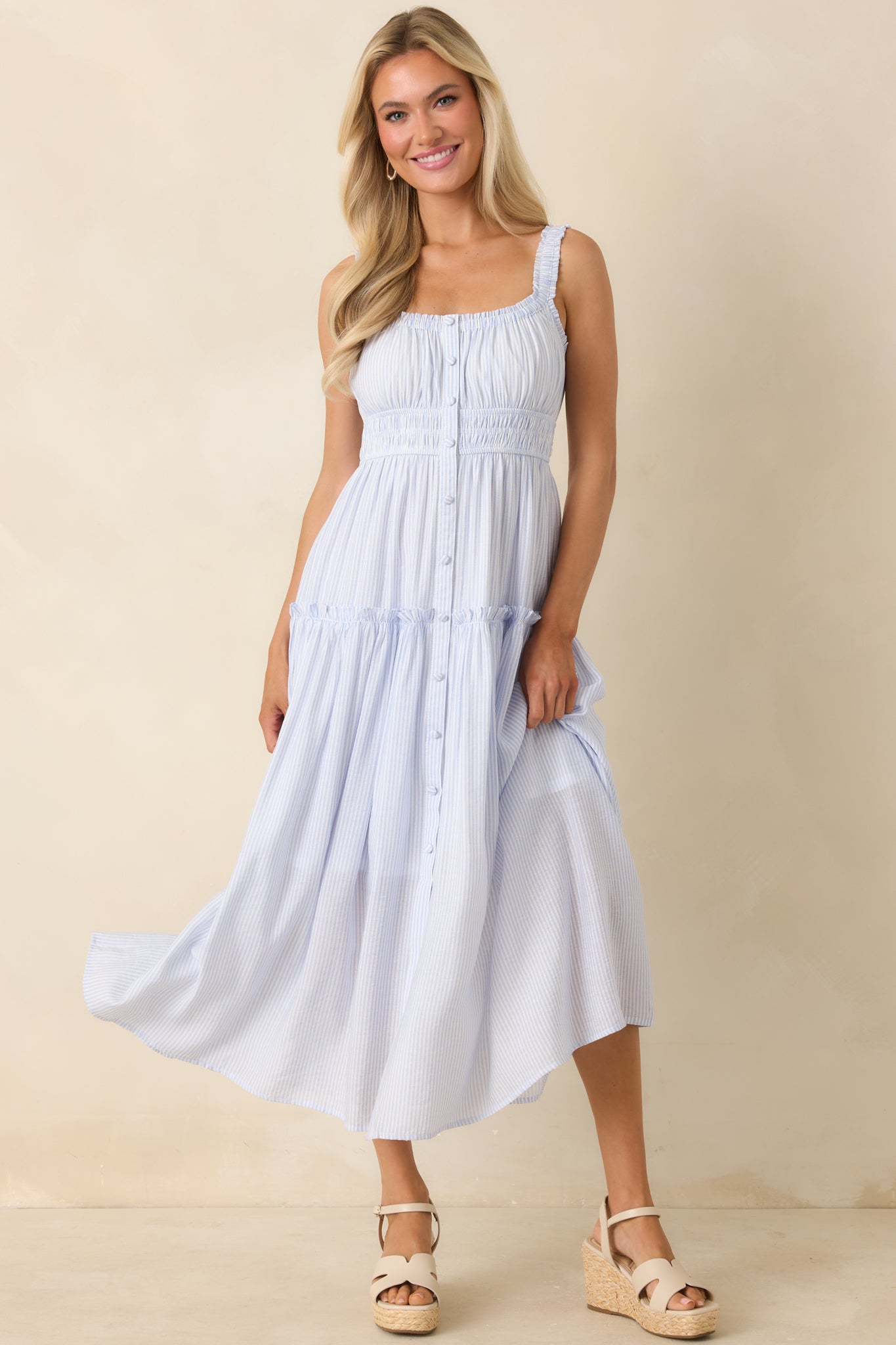 Soft pinstripe dress with smocked waist, cascading tiers, and vintage-inspired button detailing.