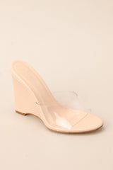 Close up view of these heels that feature a rounded toe, a clear strap over the top of the foot, and a wedged heel.