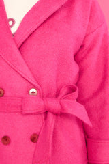 Close up view of this coat that features buttoned sleeve tabs, a double breasted buttoned closure, and an optional self-tie belt.
