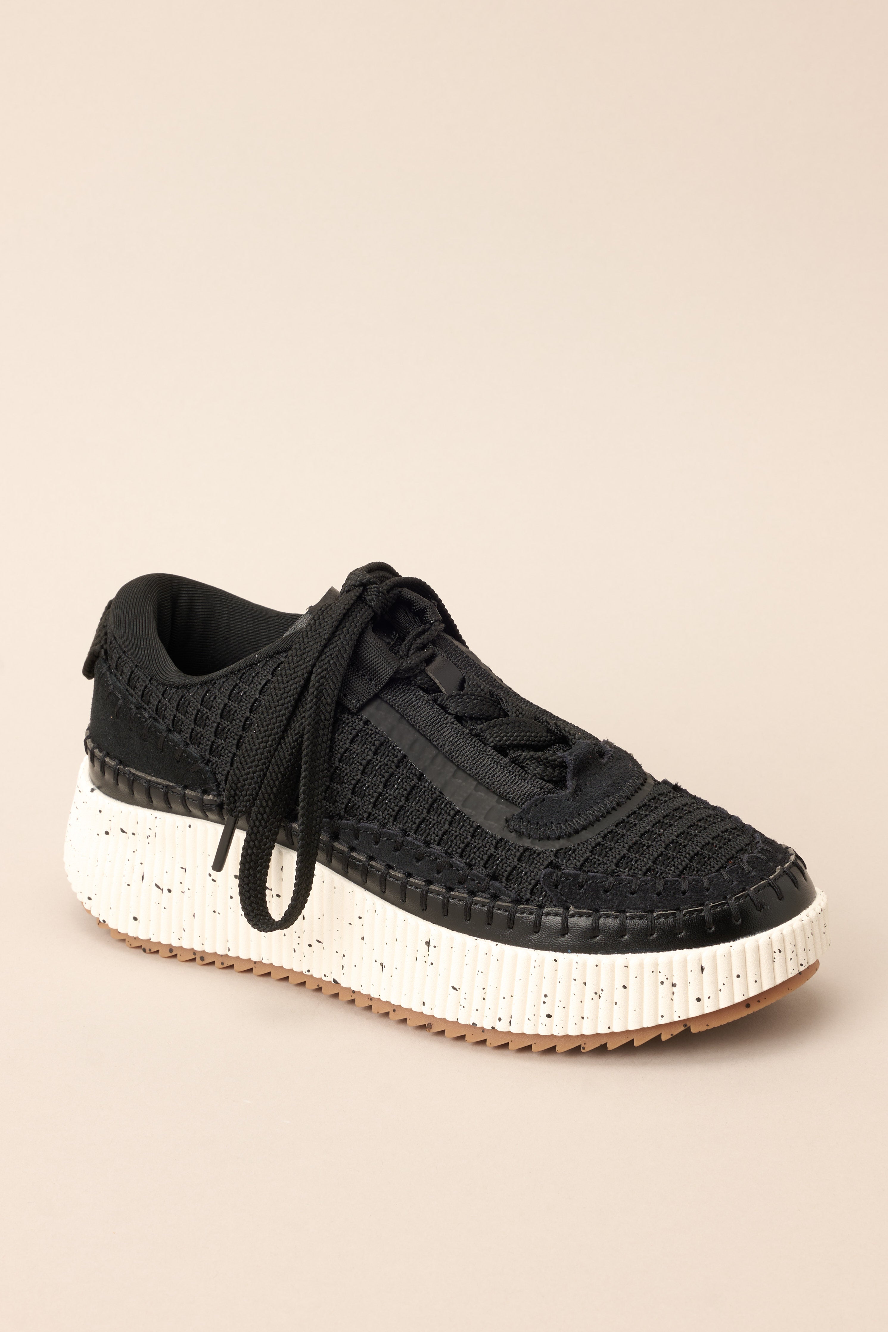 Angled outer-side view of these sneakers that feature a rounded toe, functional laces, knitted detailing throughout, a comfortable fit, and a thick sole.