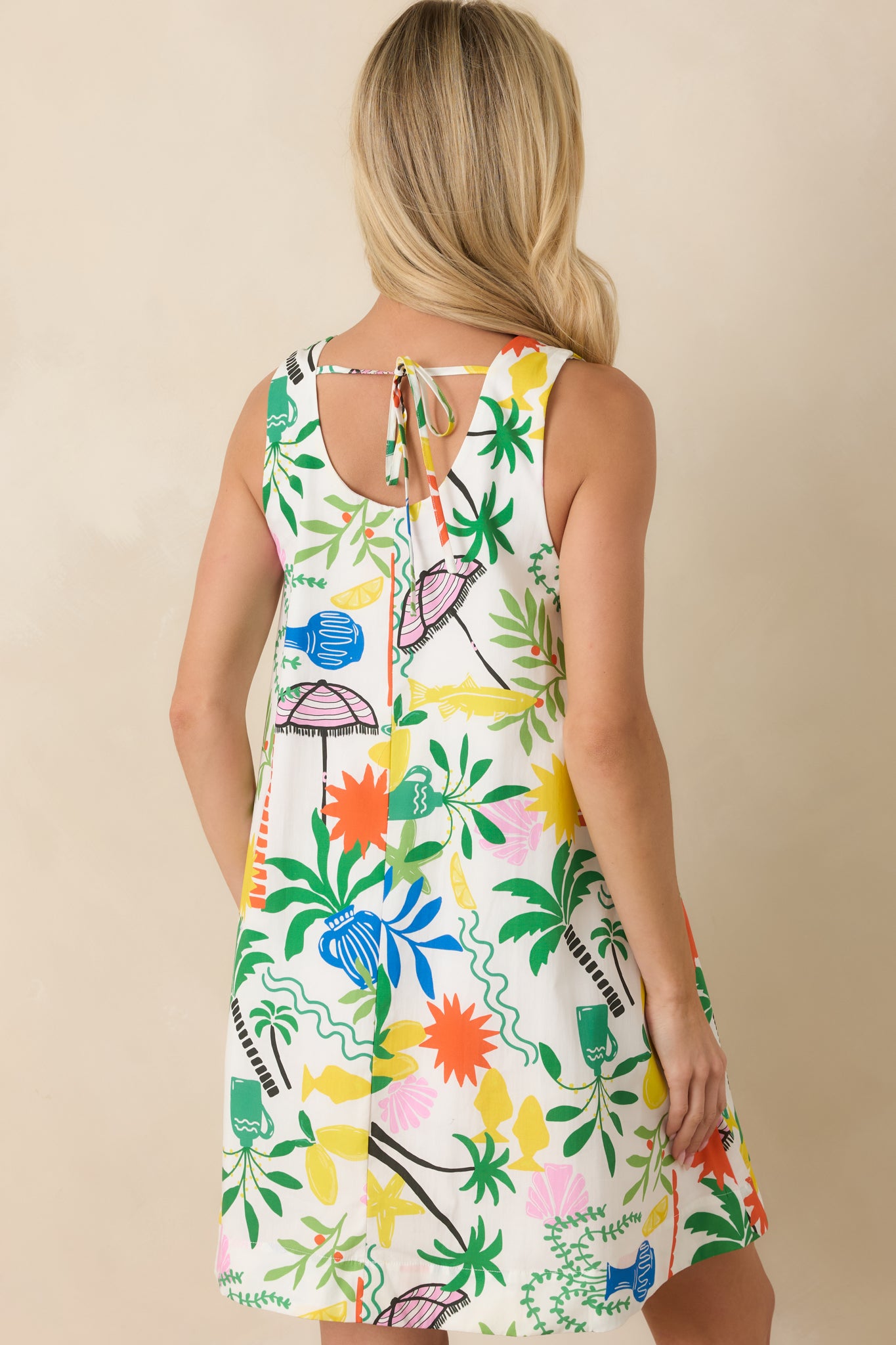 Rear view of the white multi mini dress featuring a relaxed A-line silhouette and sleeveless design.