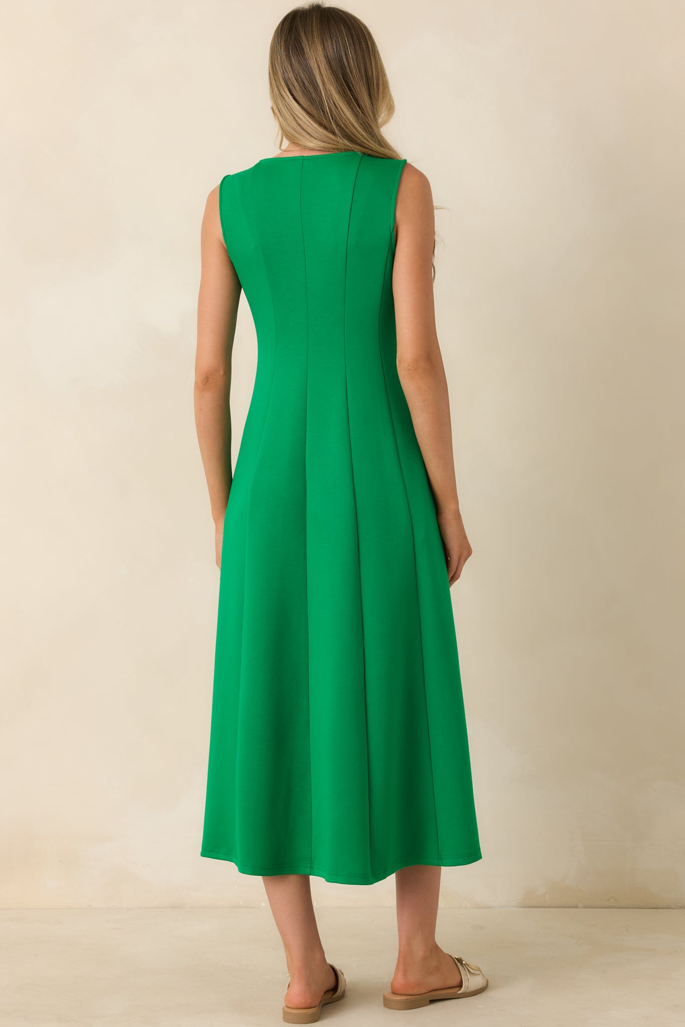 Rear view of the green midi dress featuring a sleeveless cut and fluid, flowing silhouette through the full length.