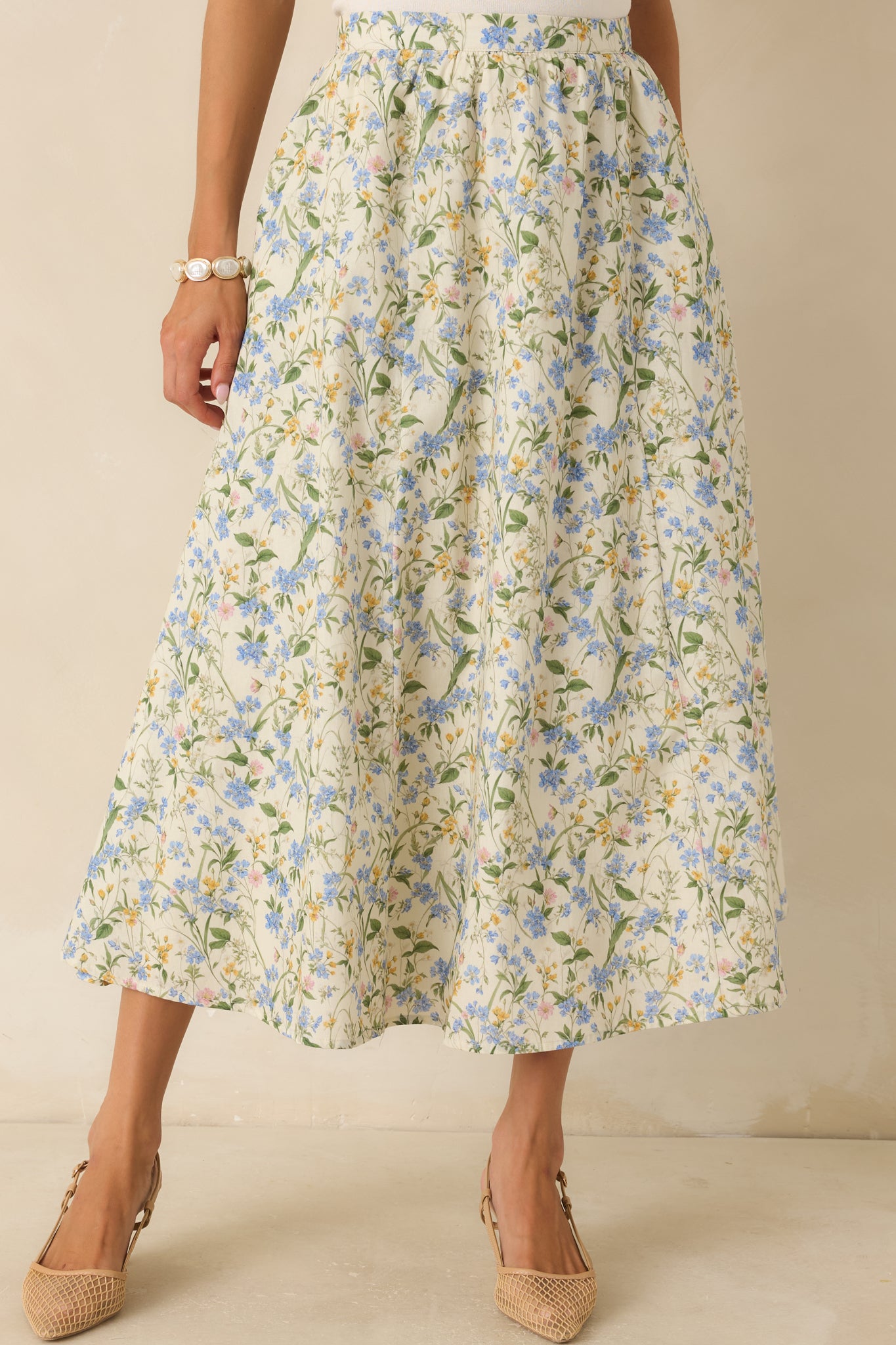 Detailed front-facing view emphasizing the side pockets and soft floral pattern across the midi-length silhouette.