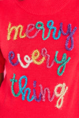 Close up view of this sweater that showcases multi-colored tinsel script that says 