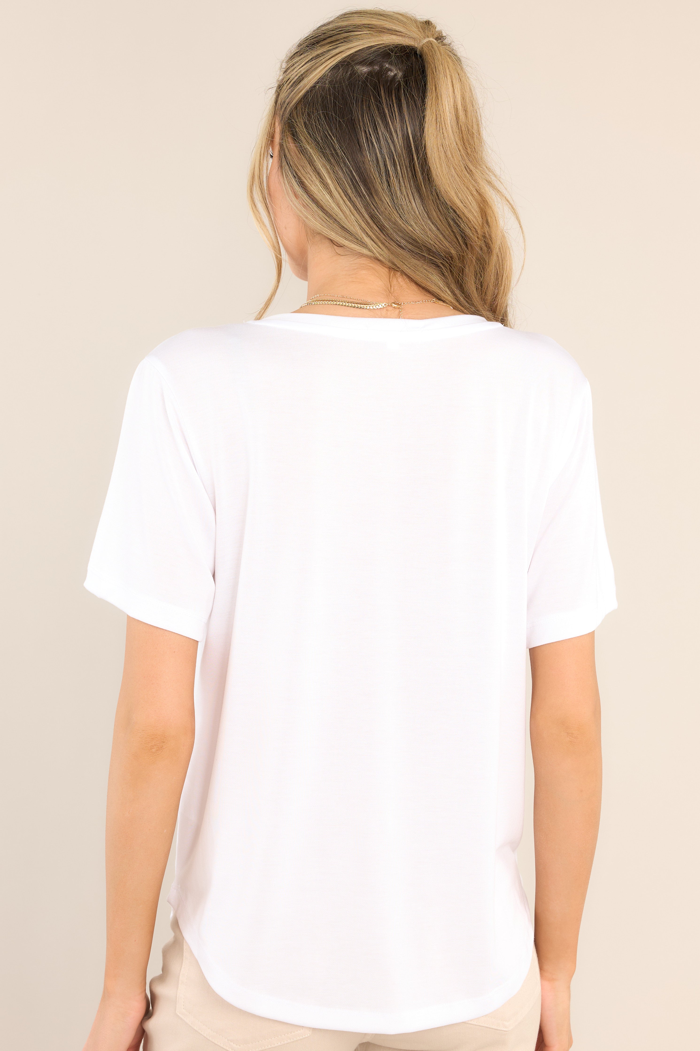 Back view of  this top that features a v-neckline, a lightweight and super soft fabric, and a scooped hemline.