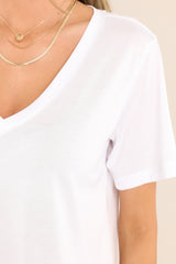 Close up view of this top that features a v-neckline, a lightweight and super soft fabric, and a scooped hemline.