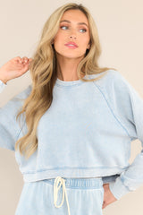 Front view of this sweatshirt that features a ribbed crew neckline, exposed seams, a washed design, ribbed cuffed long sleeves, and a cropped hemline.
