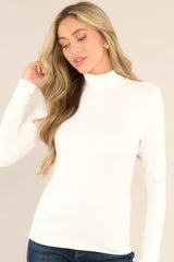 Front view of  this top that features a turtle neckline, a soft & lightweight material, and long sleeves.