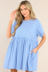 Front view of this dress that features a round neckline, a keyhole cutout at the back of the neck with a button closure, short sleeves, and functional pockets at the hips.