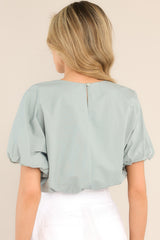 Back view of this top that features a crew neckline, elastic cuffed dolman sleeves, and an elastic cuffed cropped hemline.