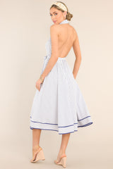 Back view of this dress that features a collared haltered v-neckline, a key-hole feature at the bust, a self-tie belt, an elastic insert in the back, and a thick cuffed hemline.