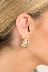 These gold earrings feature gold hardware, a textured tear shaped stud, with secure post backings.