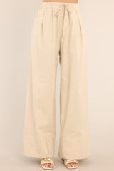 Front view of these pants that feature a high waisted design, an elastic waistband with a self-tie feature, functional pockets, and a thick ankle cuff.