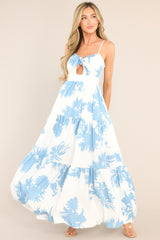 This white and blue dress features a sweetheart neckline, thin adjustable straps, a discrete back zipper, smocked back inserts, a bust cutout with a self-tie feature, and a tiered design.
