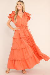 This orange dress features a v-neckline with a self-tie closure, ruffled flutter sleeves, a drawstring waistband, and a long, flowy skirt.
