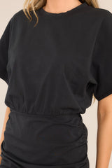 Close up view of this dress that features a crew neckline, an elastic waistband, ruching down the sides, and wide sleeves.