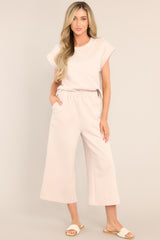 Full body view of these pants that feature a high waisted design, an elastic waistband, functional hip pockets, a textured crisscross design, and a wide leg.