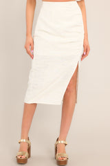 Front view of this skirt that features a high waisted design, a discrete side zipper, a thick exposed side seam with ruching, and a side slit.