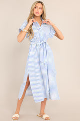 Full body view of this dress that features a collared neckline, a full button front, a fitted waist, a self-tie waist belt, functional pockets, two side slits, and folded short sleeves.