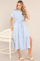 Full front view of this dress that features a collared neckline, a full button front, a fitted waist, a self-tie waist belt, functional pockets, two side slits, and folded short sleeves.