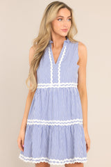 Front view of this dress that features a ruffled v-neckline, scallop detailing, functional hip pockets, and a scalloped hemline.
