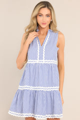 Full front view of this dress that features a ruffled v-neckline, scallop detailing, functional hip pockets, and a scalloped hemline.