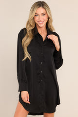 Full front view of this mini dress that features a collared neckline, functional buttons down the front, buttoned cuffed long sleeves, and a satin-like material.