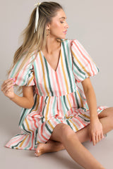This multi-colored cotton dress features a v-neckline, puff sleeves with elastic cuffs, two functional pockets, ruffle detailing along the hem, and an oversized fit throughout.