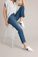 These medium wash jeans feature a high rise design, a classic button and zipper closure, functional belt loops and pockets, and a cropped hemline.