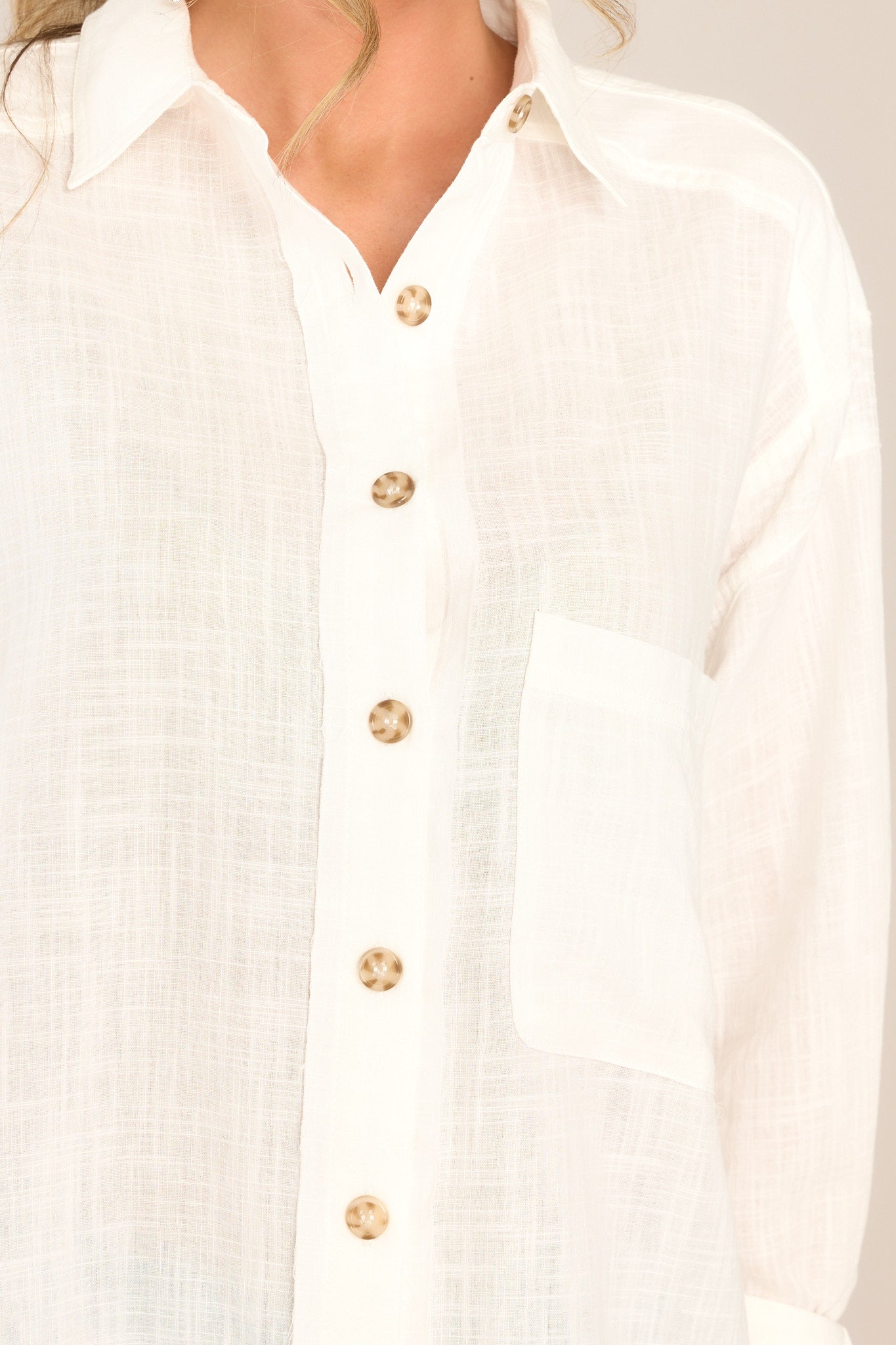 Close-up detailed view of top that features a collared neckline, functional buttons, and a front side pocket.