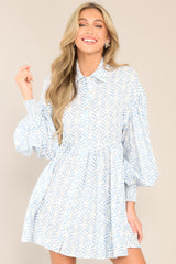 This blue print dress features a collared neckline, functional buttons down the front, long sleeves with smocked cuffs, and a flowy, relaxed fit throughout.